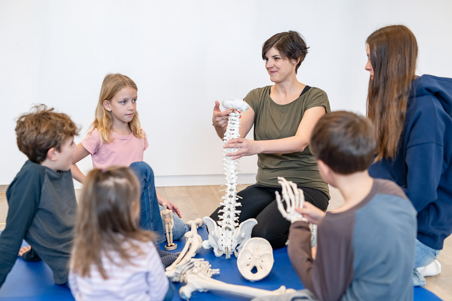 Julia Zeiner-Mayrhofer Julia Zeiner-Mayrhofer erklärt einer Gruppe Kinder das Modell der Wirbelsäule